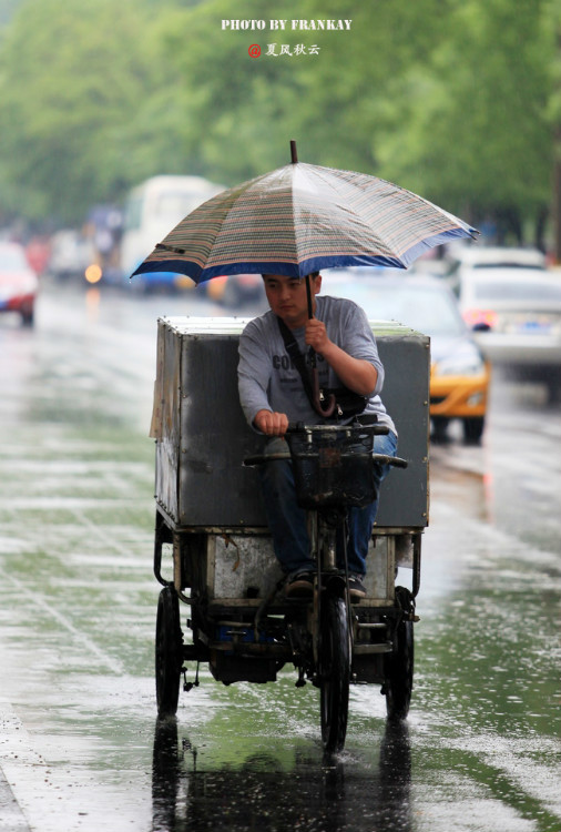 【实拍】北京入夏第一场雨:雨中奔波忙碌的人们]