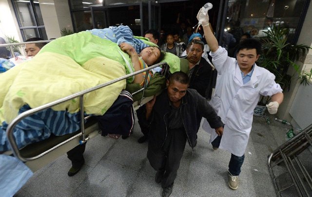 2013年4月20日,四川省芦山县,救援人员将一名伤者用担架抬入芦山人民