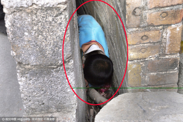 因为贪玩钻到墙缝里,结果被紧紧卡住