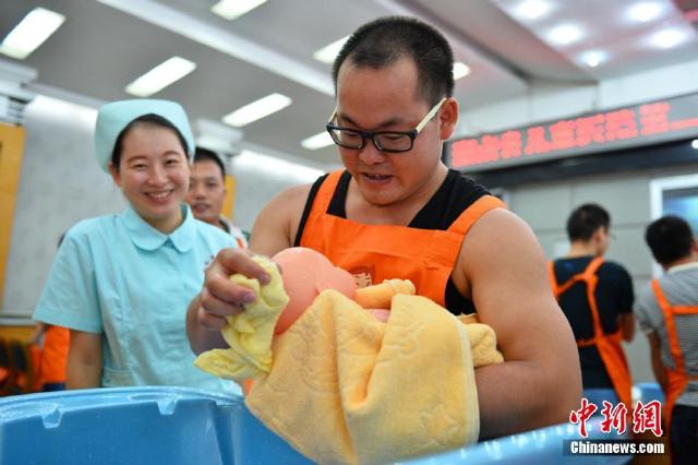 "菜鸟"奶爸们集体走进课堂,学习为孩子洗澡,换尿布,喂奶,抱孩子等必修