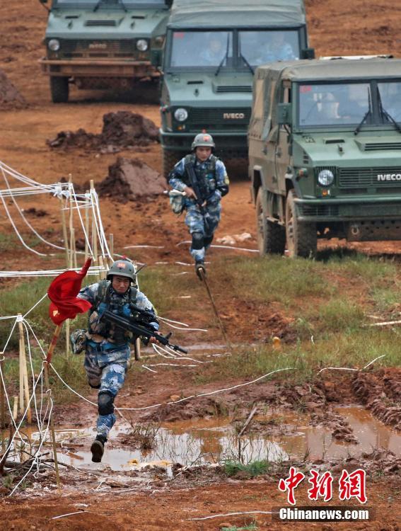 图为海军陆战队员下车后迅速前出.中新社发 胡锴冰 摄