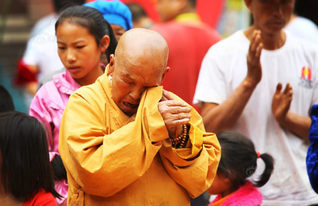 81岁老僧在祈福过程中擦拭眼睛.